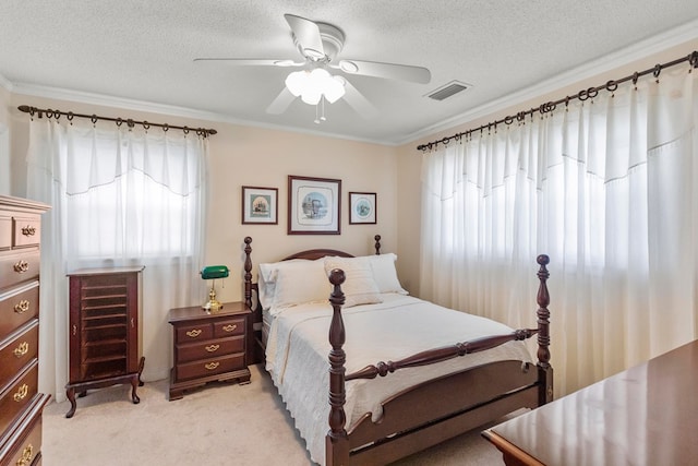 bedroom with ceiling fan, crown molding, light carpet, and a textured ceiling