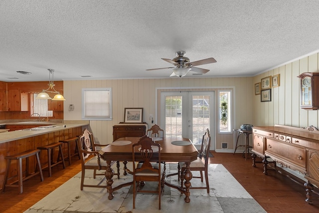 dining area with dark wood-type flooring, ceiling fan, and french doors