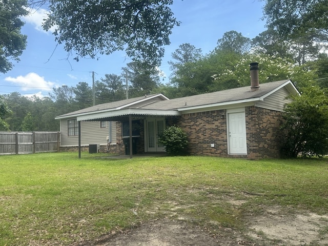 rear view of house with a yard and central AC unit