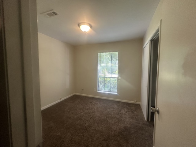 empty room with dark colored carpet