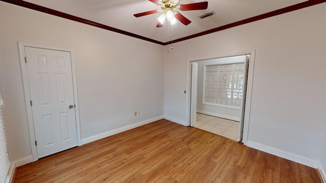 spare room featuring ceiling fan, ornamental molding, and light wood-type flooring