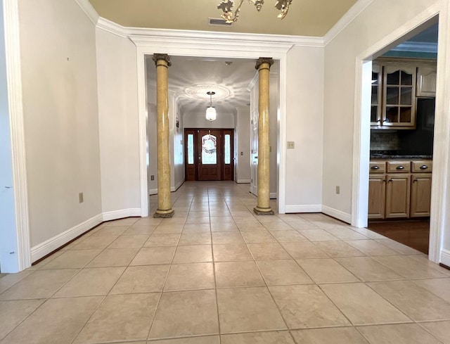 tiled entrance foyer with decorative columns and crown molding