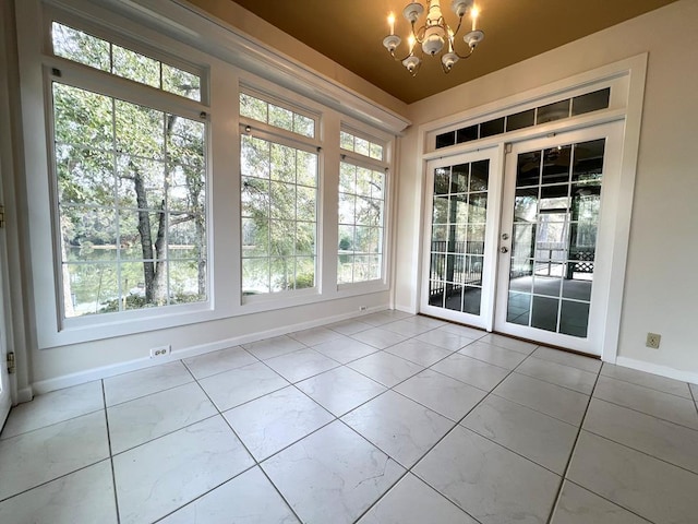 unfurnished sunroom with french doors and a notable chandelier