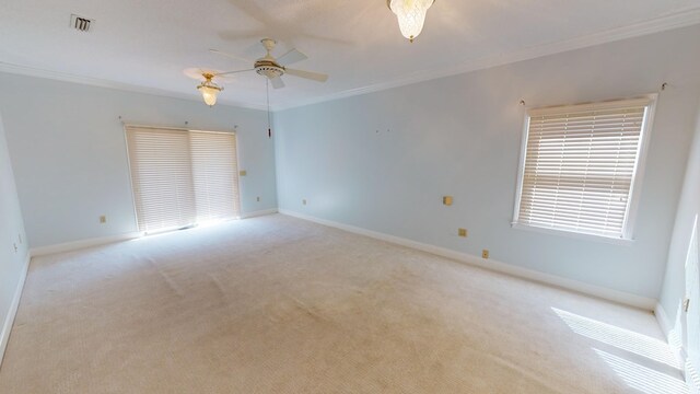 spare room featuring ceiling fan, light colored carpet, and crown molding