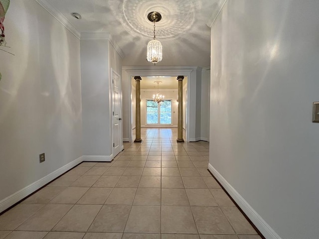 hallway featuring decorative columns, crown molding, light tile patterned floors, and a chandelier