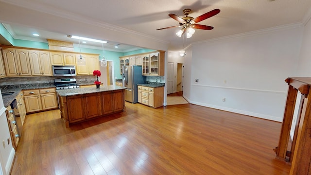 kitchen with decorative backsplash, stainless steel appliances, crown molding, a center island, and light hardwood / wood-style floors