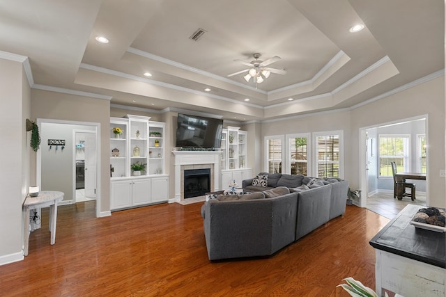 106 Lake Ln, Headland, AL 36345 - living area with a ceiling fan, a fireplace, a tray ceiling, crown molding, and baseboards