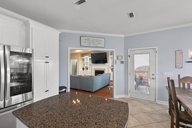 106 Lake Ln, Headland, AL 36345 - kitchen with smart refrigerator, crown molding, white cabinets, dark stone countertops, and light tile patterned flooring