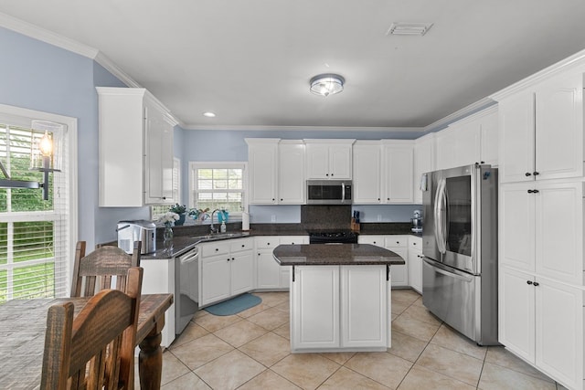 106 Lake Ln, Headland, AL 36345 - kitchen with stainless steel appliances, a sink, white cabinetry, a center island, and crown molding