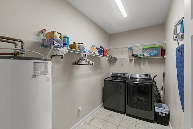 106 Lake Ln, Headland, AL 36345 - laundry area featuring water heater, washing machine and dryer, light tile patterned flooring, and baseboards