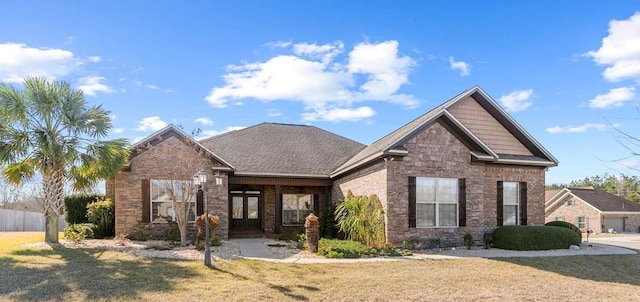 craftsman-style home featuring stone siding and a front yard