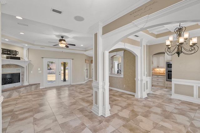 unfurnished living room with visible vents, arched walkways, ornamental molding, french doors, and a fireplace