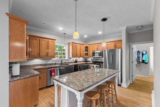 408 Shakespeare Dr, Dothan, AL 36303 - kitchen featuring stainless steel appliances, a kitchen breakfast bar, crown molding, light wood-type flooring, and a sink