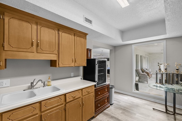 408 Shakespeare Dr, Dothan, AL 36303 - kitchen featuring a sink, a textured ceiling, light countertops, light wood-style floors, and baseboards