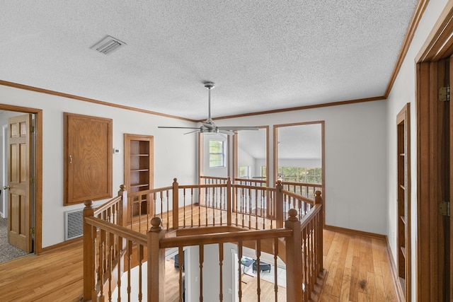 408 Shakespeare Dr, Dothan, AL 36303 - corridor with an upstairs landing, light wood-style floors, a textured ceiling, crown molding, and baseboards