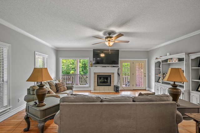 408 Shakespeare Dr, Dothan, AL 36303 - living room featuring wood finished floors, a ceiling fan, healthy amount of natural light, a tile fireplace, and crown molding