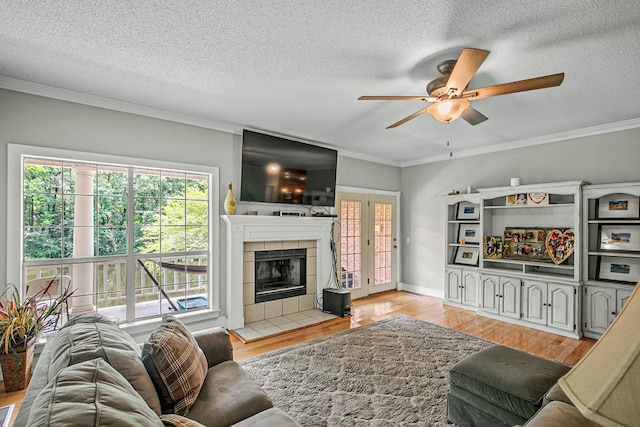 408 Shakespeare Dr, Dothan, AL 36303 - living room featuring ceiling fan, a textured ceiling, plenty of natural light, light wood finished floors, and a tile fireplace