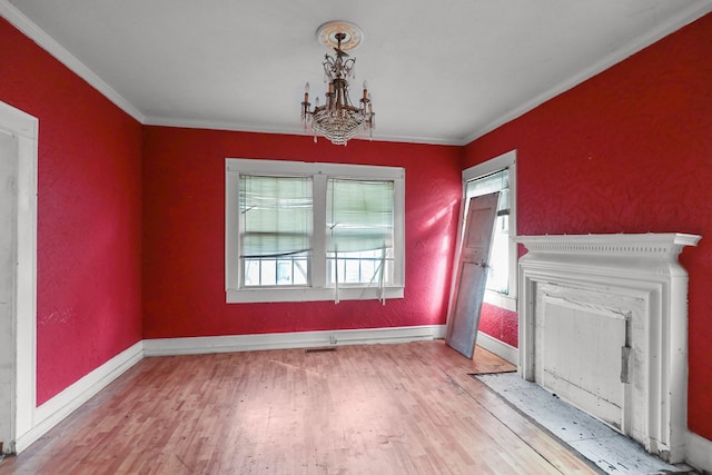 unfurnished dining area featuring hardwood / wood-style flooring, ornamental molding, and a chandelier