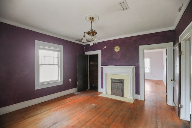 unfurnished living room featuring a brick fireplace, hardwood / wood-style flooring, and a wealth of natural light