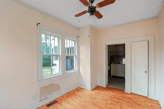 spare room featuring crown molding, light hardwood / wood-style flooring, and ceiling fan