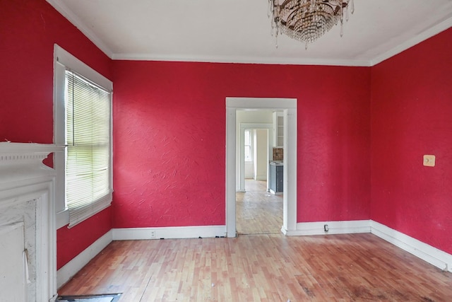 empty room featuring crown molding and wood-type flooring