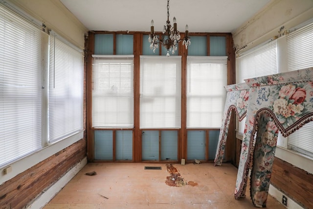 sunroom / solarium with a notable chandelier