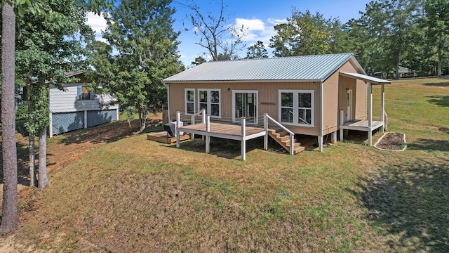 back of house with a deck, a yard, and an outbuilding