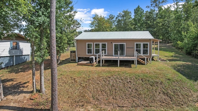 rear view of house featuring a yard and a deck