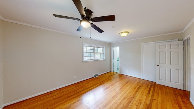 unfurnished bedroom with hardwood / wood-style floors, a closet, ceiling fan, and crown molding