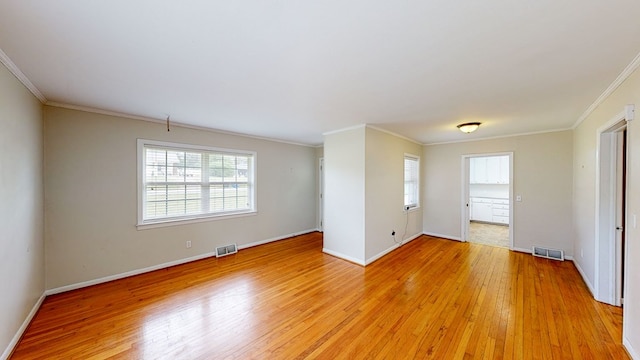 empty room featuring light wood-type flooring and crown molding