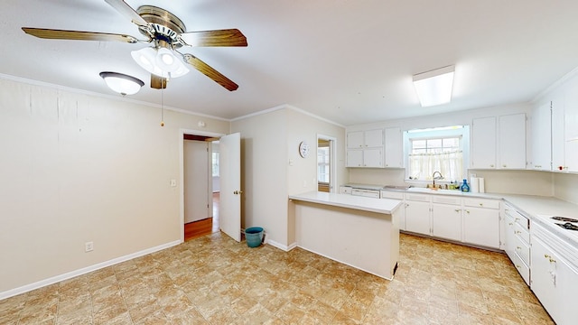 kitchen featuring white cabinetry, sink, ceiling fan, kitchen peninsula, and crown molding