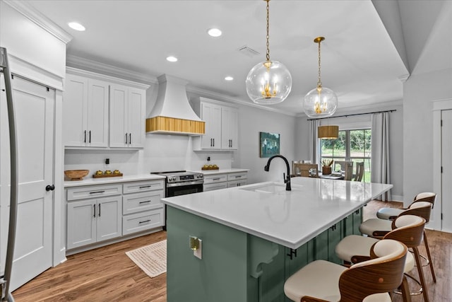246 Suggs Rd, Dothan, AL 36345 - kitchen with premium range hood, stainless steel range with electric cooktop, light wood finished floors, an island with sink, and recessed lighting