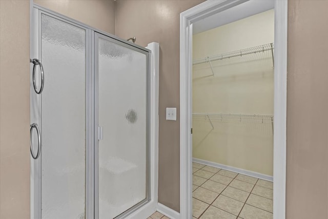 bathroom featuring walk in shower and tile patterned flooring