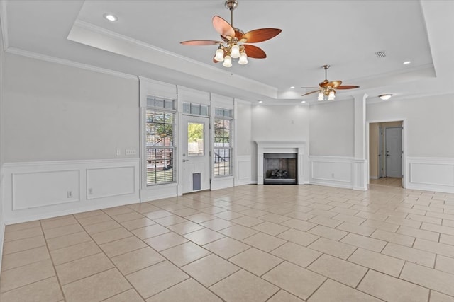 unfurnished living room featuring ornamental molding, ceiling fan, a raised ceiling, and light tile patterned floors