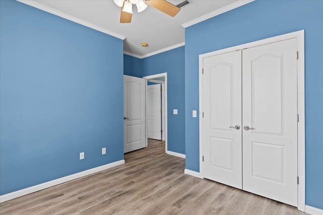 unfurnished bedroom featuring ornamental molding, light wood-type flooring, ceiling fan, and a closet