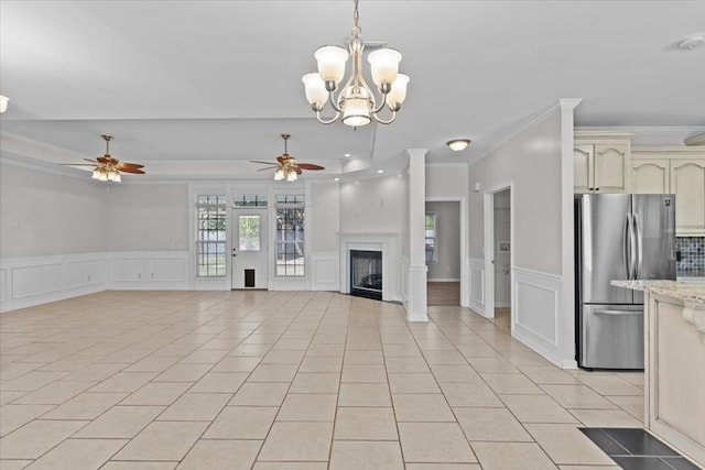 unfurnished living room featuring ceiling fan with notable chandelier, light tile patterned floors, and crown molding