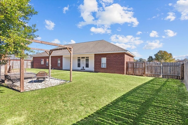 back of house with a yard, french doors, an outdoor fire pit, and a patio