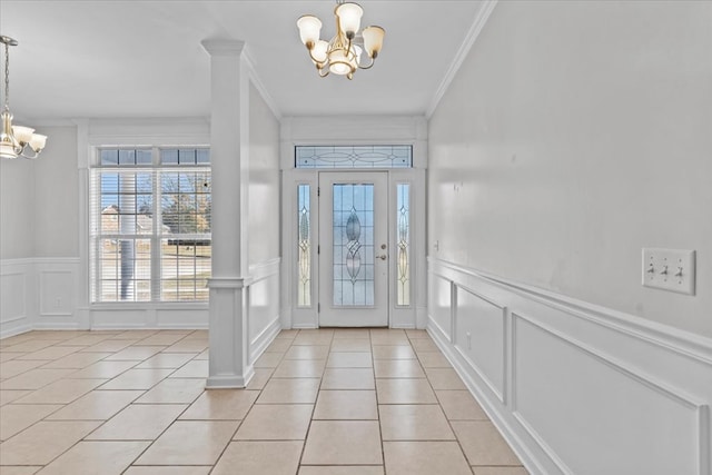 tiled foyer featuring a notable chandelier and crown molding