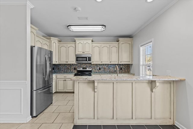 kitchen featuring appliances with stainless steel finishes, ornamental molding, light tile patterned flooring, light stone counters, and backsplash