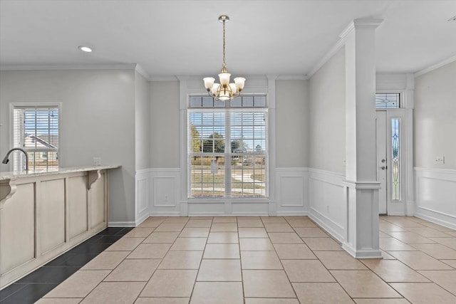 unfurnished dining area with a healthy amount of sunlight, light tile patterned floors, and ornamental molding