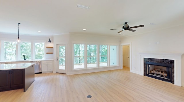 61 Memory Ln, Eufaula, AL 36027 - unfurnished living room with a sink, light wood-style flooring, ceiling fan, a fireplace, and crown molding