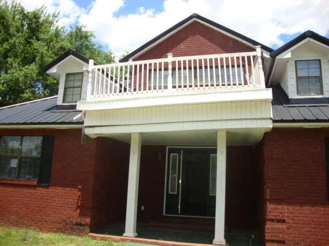 801 Early Walden Rd, Headland, AL 36345 - rear view of property with a balcony, brick siding, and metal roof