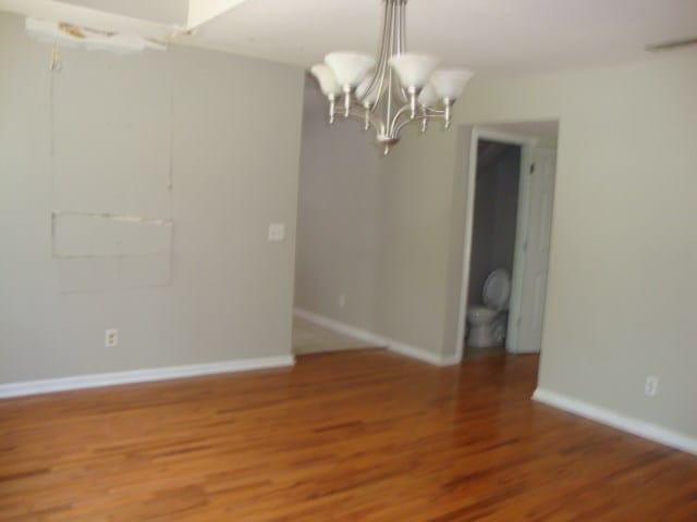 801 Early Walden Rd, Headland, AL 36345 - unfurnished dining area with a chandelier, light wood-type flooring, and baseboards