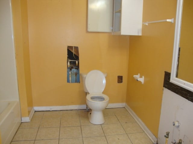 801 Early Walden Rd, Headland, AL 36345 - full bathroom featuring toilet, tile patterned flooring, a bathtub, and baseboards
