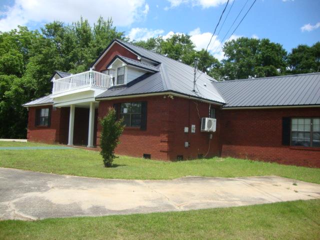 801 Early Walden Rd, Headland, AL 36345 - view of front of house with a balcony, brick siding, metal roof, and crawl space