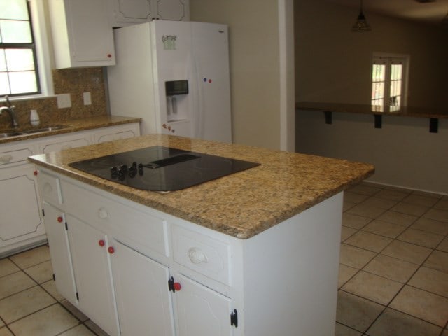 801 Early Walden Rd, Headland, AL 36345 - kitchen with white refrigerator with ice dispenser, black electric cooktop, a sink, a center island, and light tile patterned floors