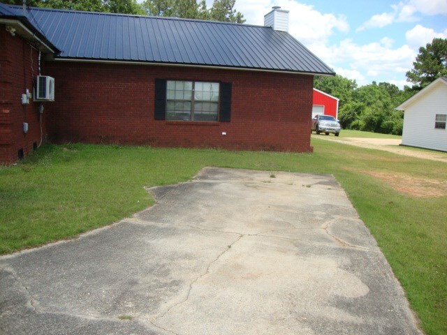 801 Early Walden Rd, Headland, AL 36345 - view of side of property featuring metal roof, a chimney, a yard, and brick siding