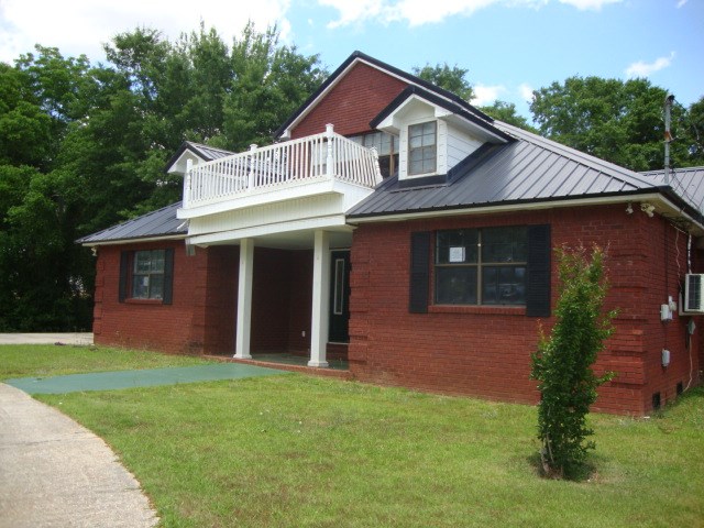 801 Early Walden Rd, Headland, AL 36345 - view of front of home featuring a balcony, a front lawn, metal roof, and brick siding