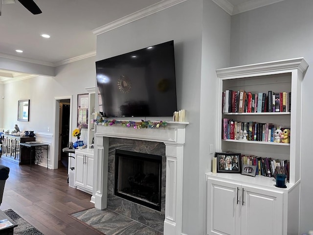 living room with a ceiling fan, a premium fireplace, dark wood finished floors, recessed lighting, and ornamental molding