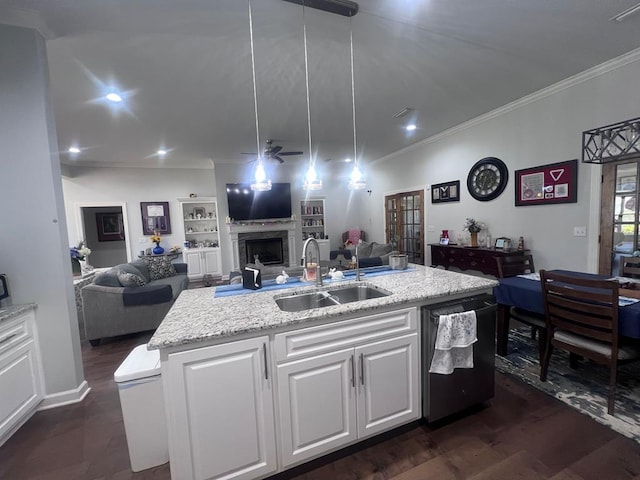 kitchen with a ceiling fan, a sink, open floor plan, a fireplace, and dishwashing machine